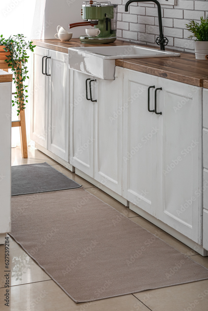 Stylish rugs on floor in kitchen