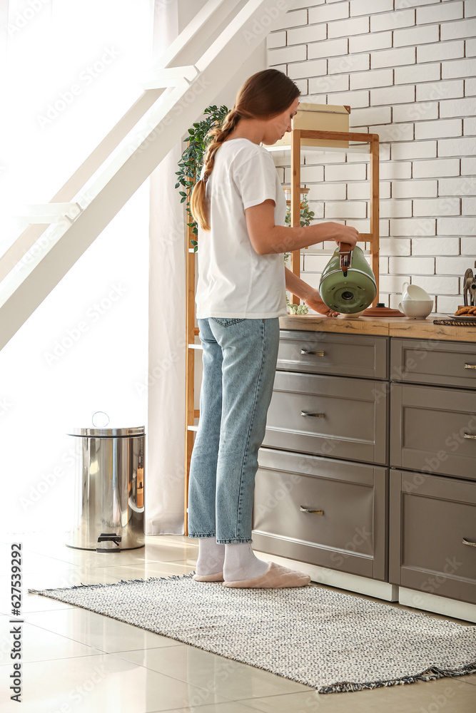 Woman standing on rug in kitchen