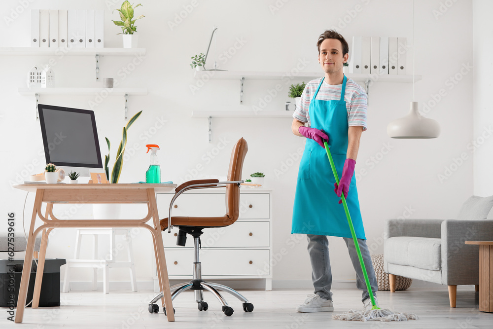 Young man mopping floor at home