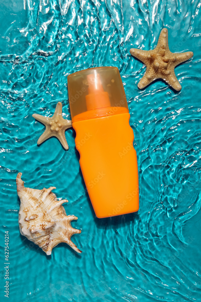 Sunscreen cream with starfishes and seashells in water on color background