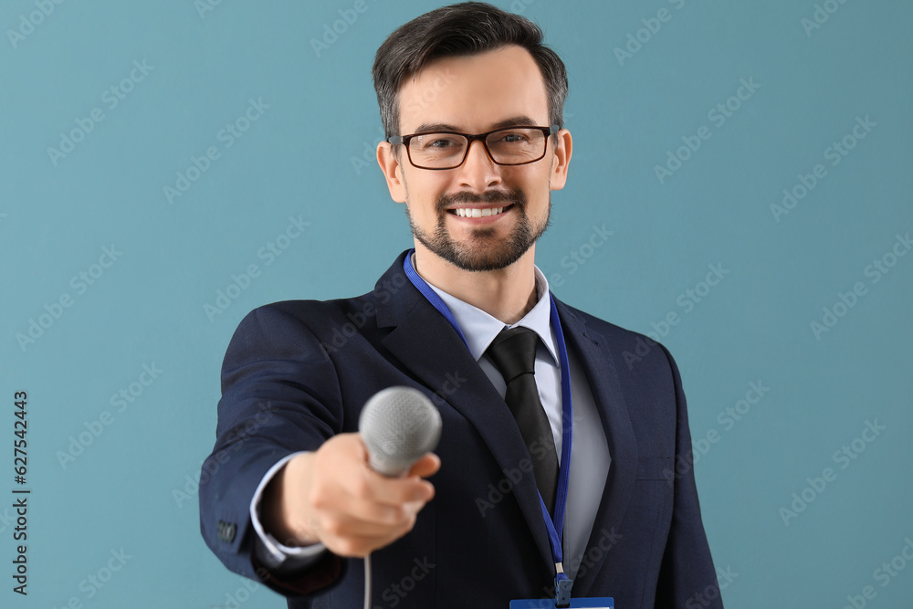 Male journalist with microphone on blue background, closeup