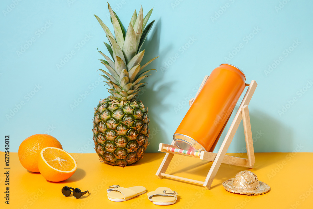 Can of soda with beach decor and fruits on table near blue wall