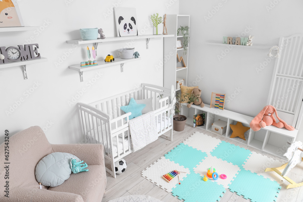 Stylish interior of childrens room with baby bed and toys