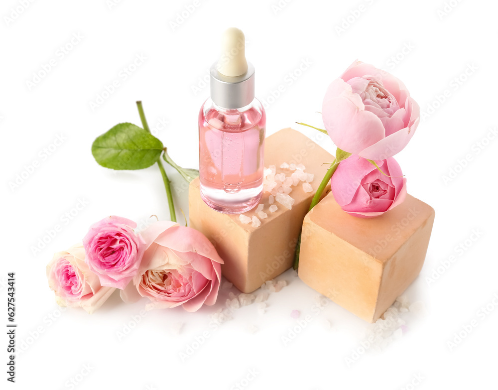 Bottle of cosmetic oil with rose extract and flowers on white background