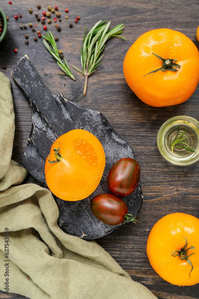 Board with different fresh tomatoes on wooden background