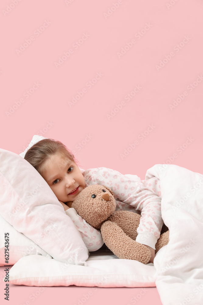 Little girl with toy and soft blanket lying on pink background