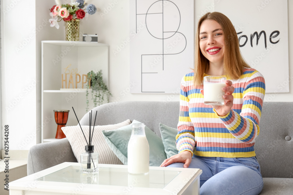 Young woman with glass of milk at home