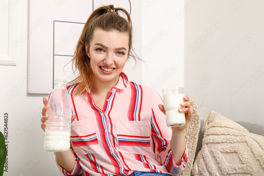 Young woman with bottle and glass of milk at home