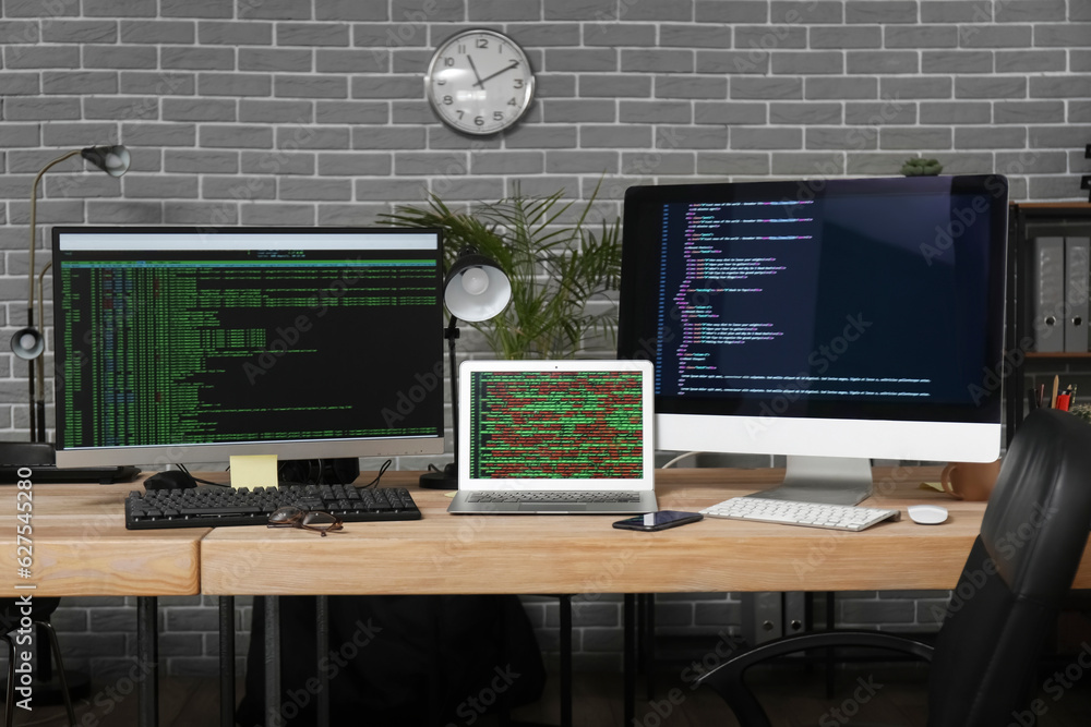 Programmers workplace with programming code on computer monitors