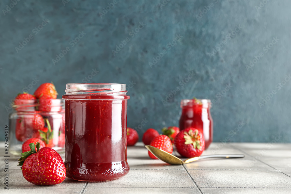 Jar of sweet strawberry jam on table