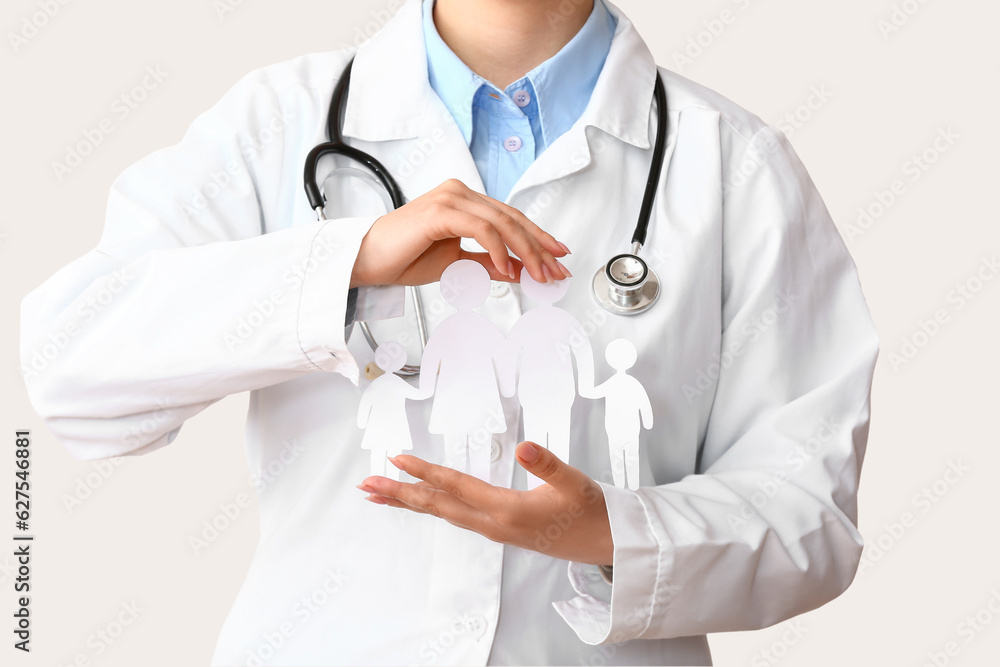 Female doctor with figures of family and stethoscope on white background. Health care concept