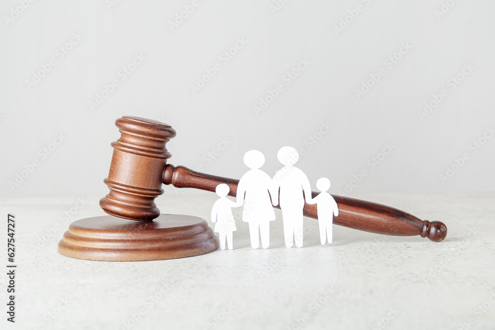 Figures of family with judges gavel on light table