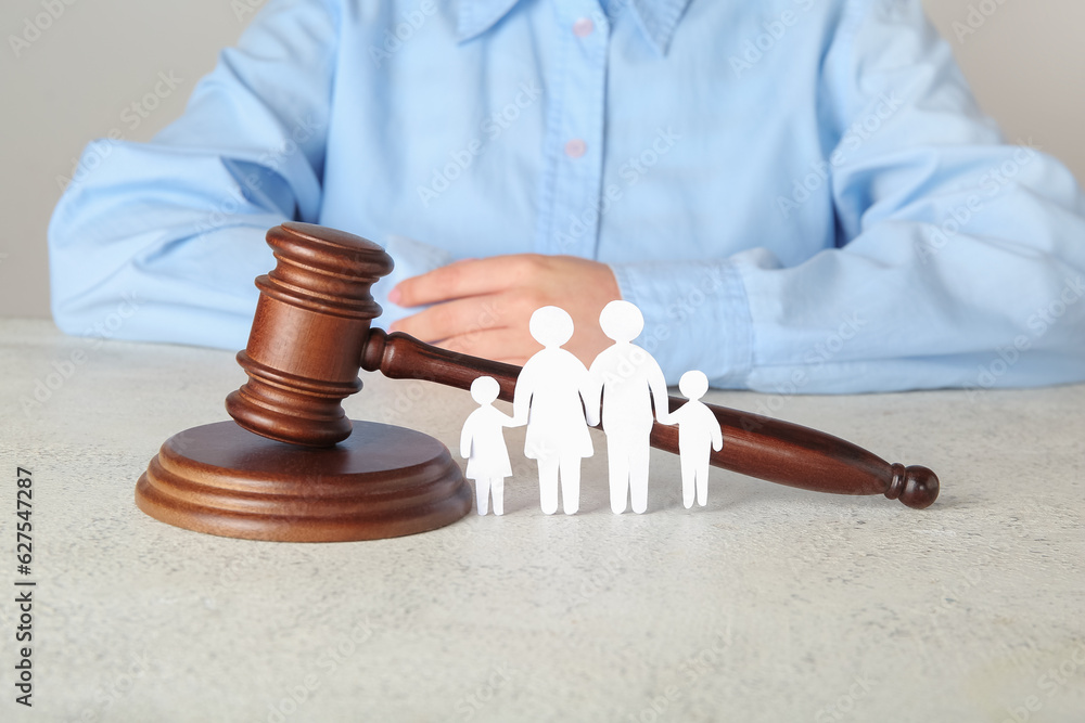 Woman with figures of family and judges gavel on light table