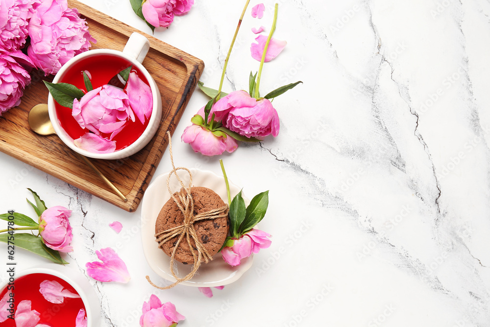 Composition with cups of tea, cookies and beautiful peony flowers on light background