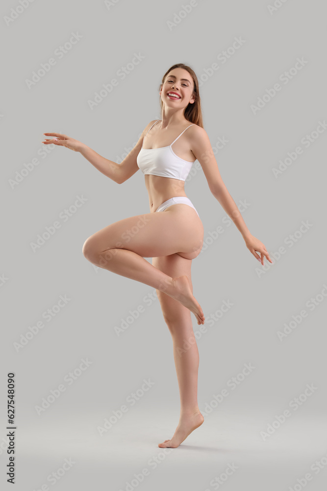 Young woman with cellulite problem on light background