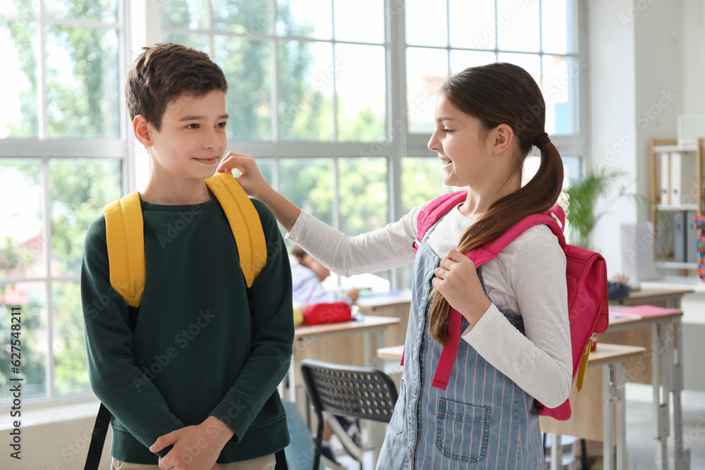 Little pupils with backpacks in classroom