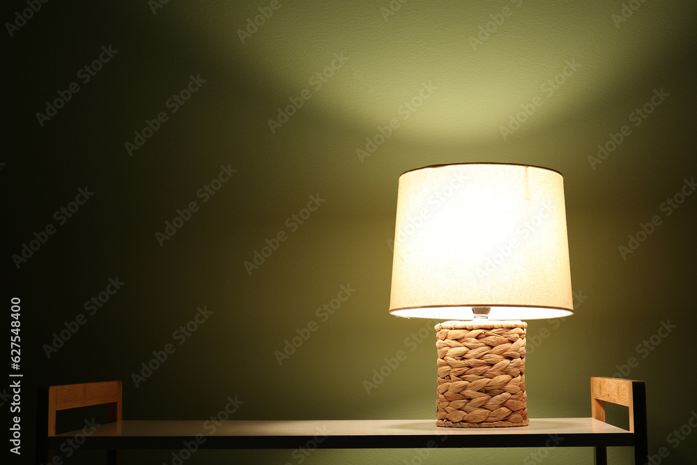 Glowing lamp on shelving unit in dark room