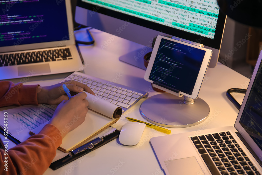 Female programmer working in office at night, closeup