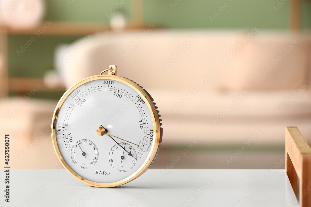 Aneroid barometer on white table in room, closeup