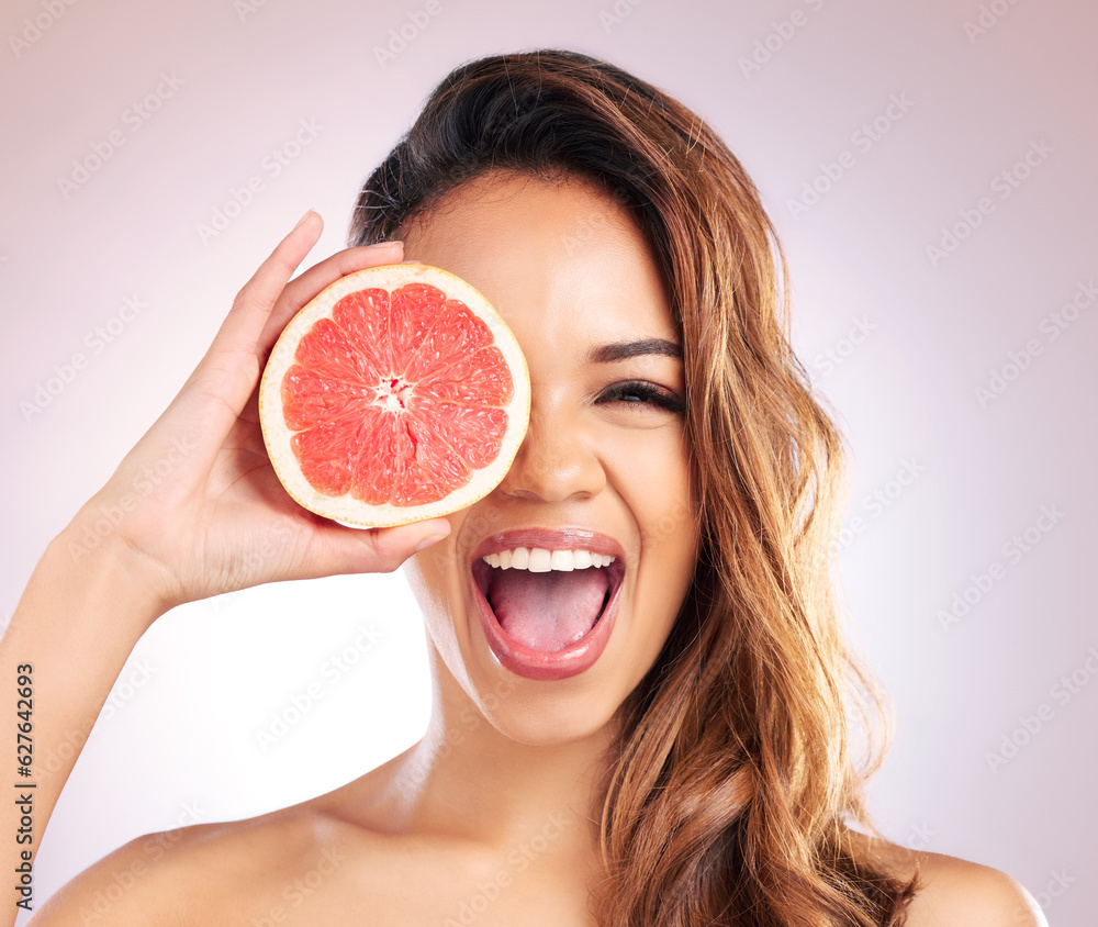 Portrait of woman, excited or grapefruit for vitamin C skincare against a studio background. Face of