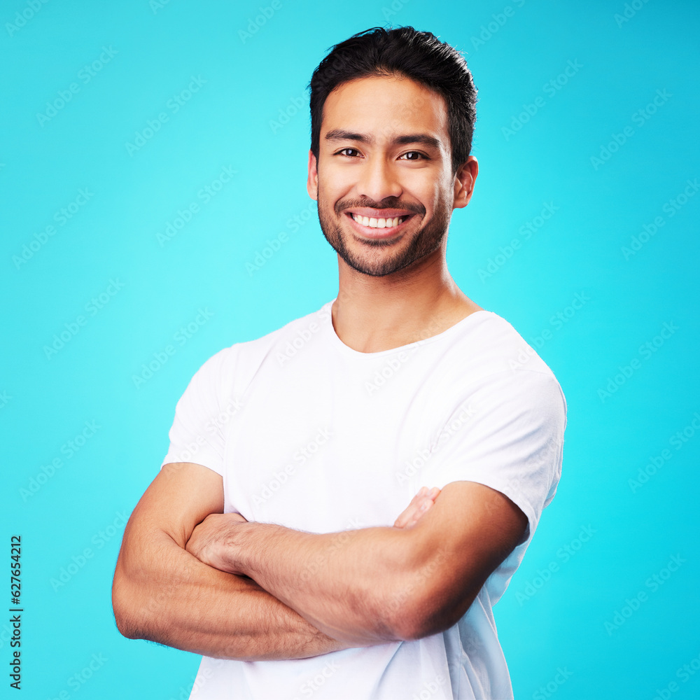 Smile, happy and portrait of Asian man arms crossed with casual fashion isolated in a studio blue ba