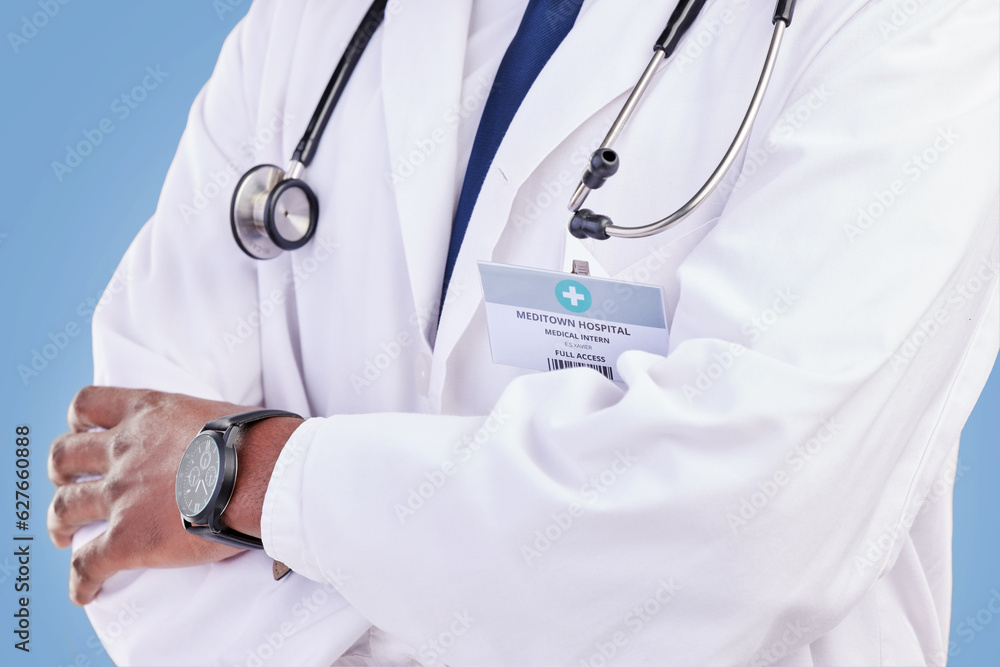 Doctor, stethoscope and arms crossed in studio with a medical expert or healthcare worker on blue ba