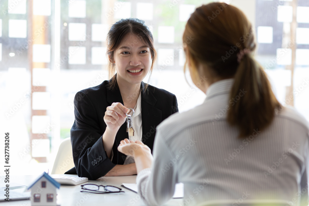 Businesswoman real estate agent hands over the house keys to a homebuyer after the purchase agreemen