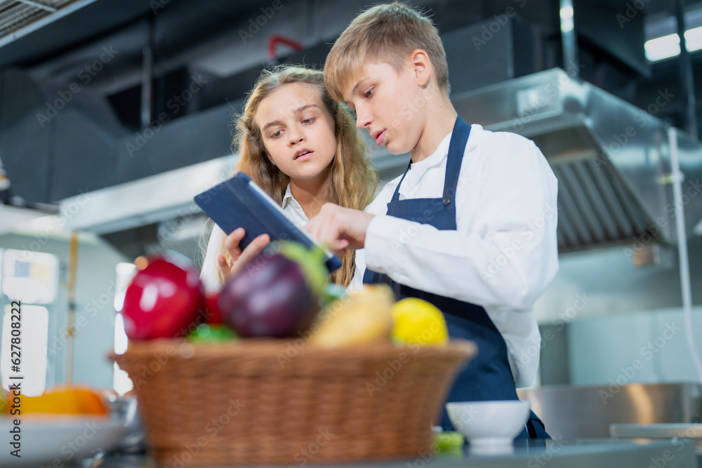 Young chef cooking at restaurant kitchen.