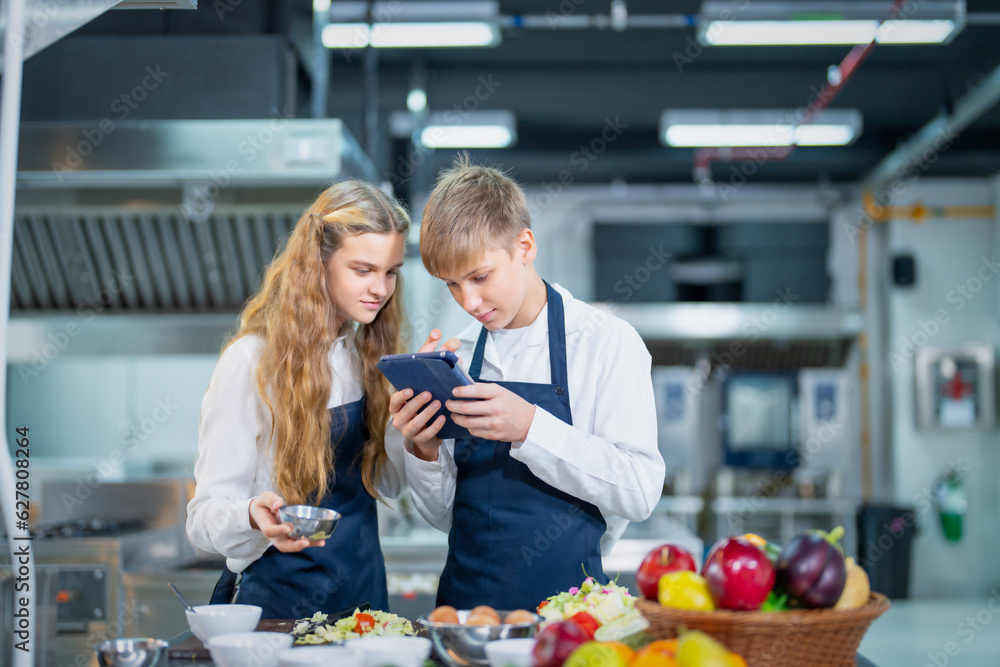 Young chef cooking at restaurant kitchen.