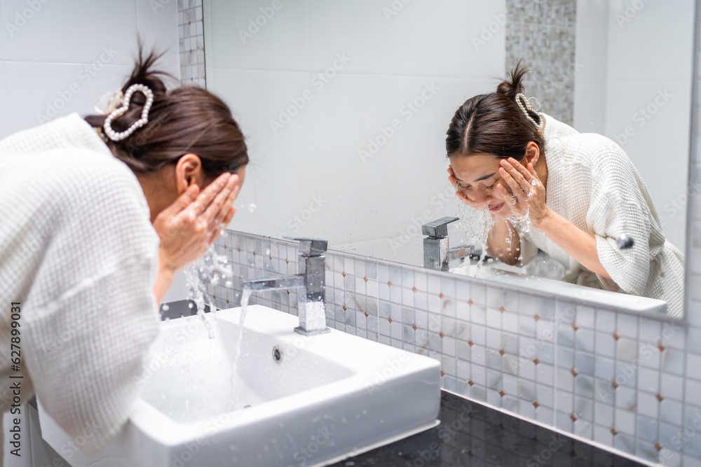 Asian beautiful woman washing her clean face with facial foam and water. 