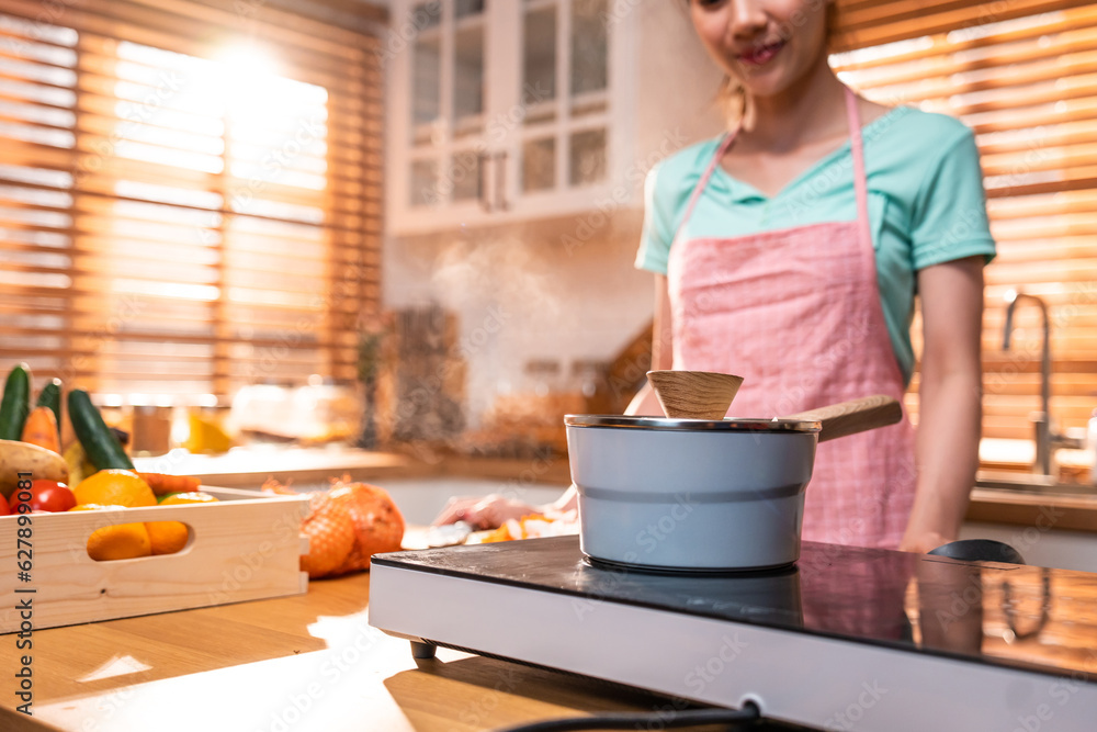 Close up of Asian young woman spending leisure time in kitchen at home.  