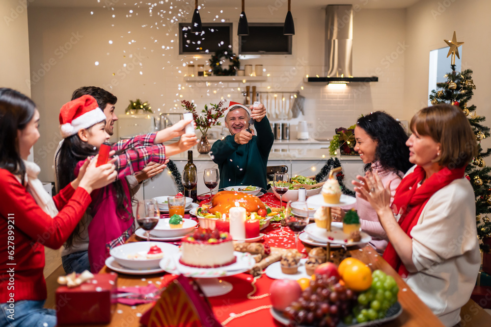 Multi-ethnic big family celebrating Christmas party together in house. 