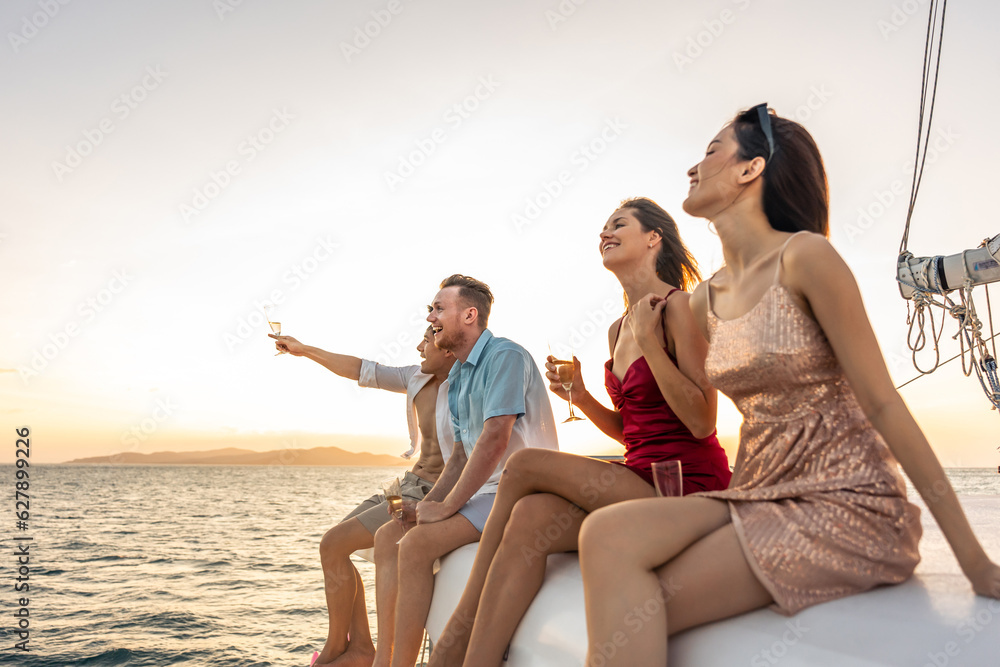 Group of diverse friends drink champagne while having a party in yacht. 