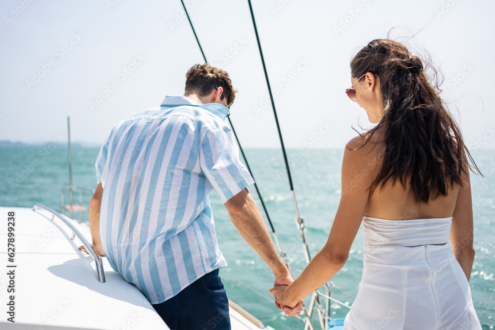 Asian young romantic couple looking at beautiful view during yachting. 