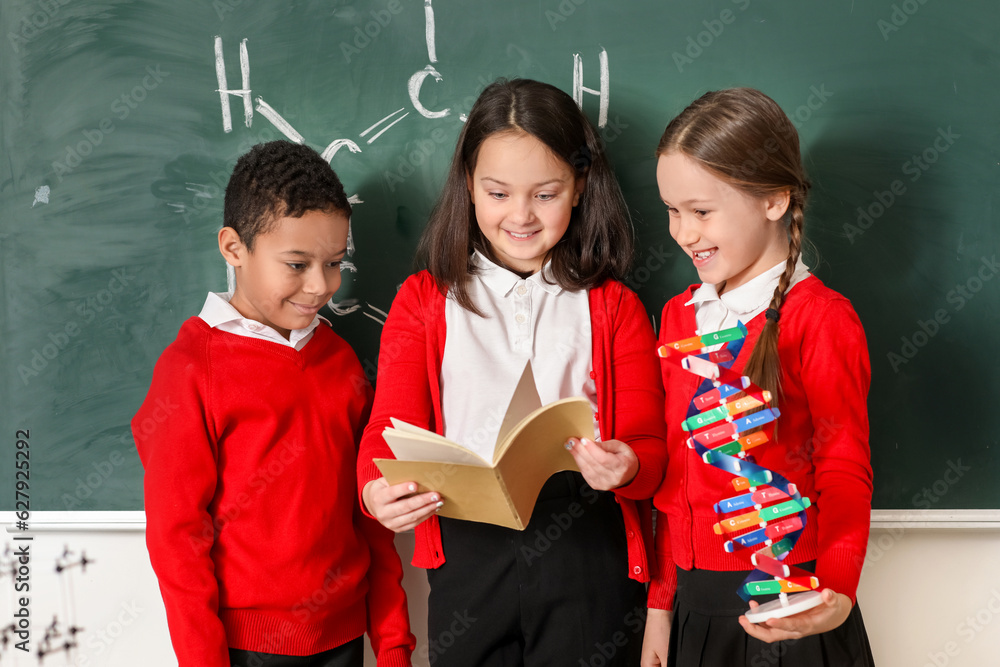 Little children with copybook and molecular model in science classroom