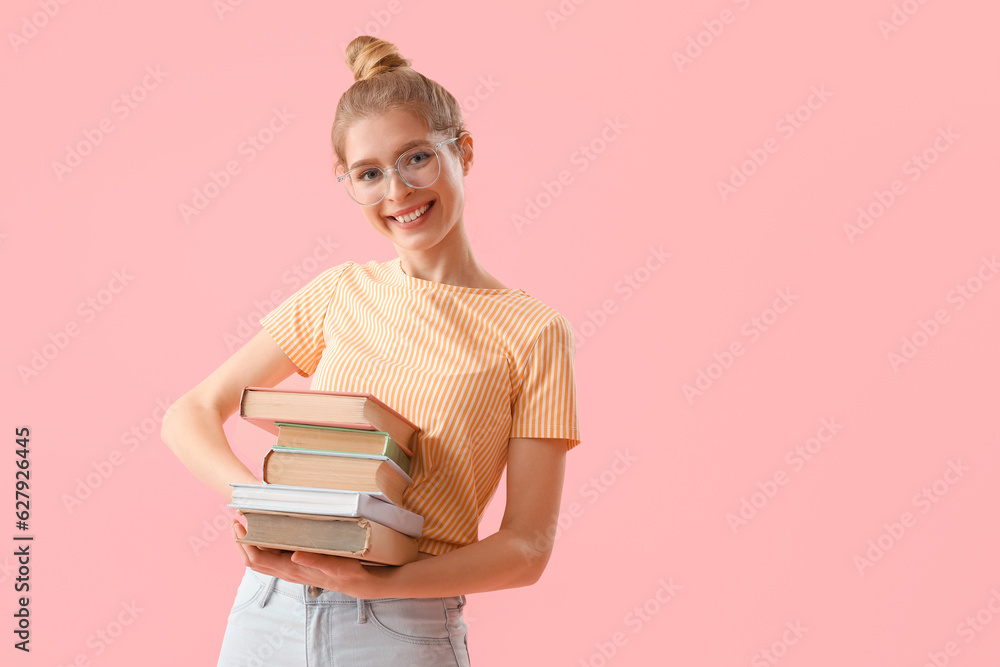 Young woman with books on pink background