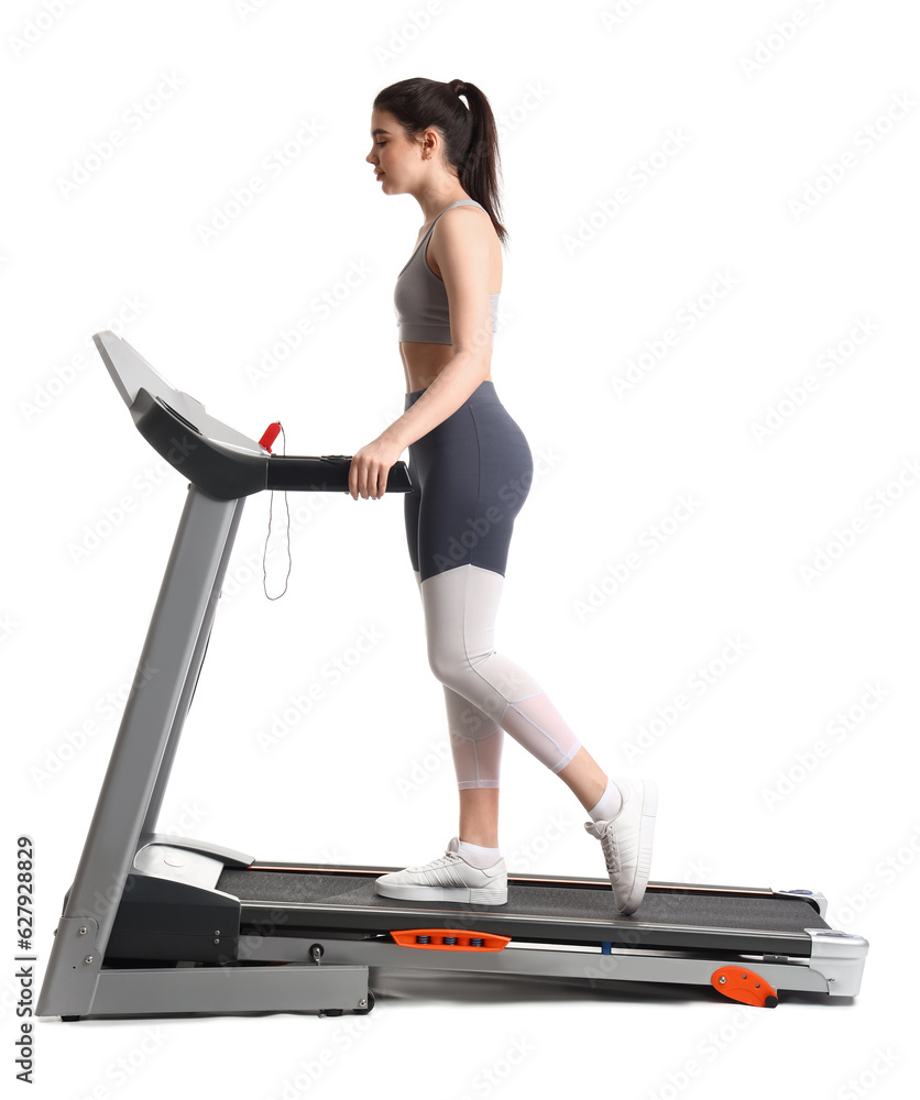 Sporty young woman training on treadmill against white background