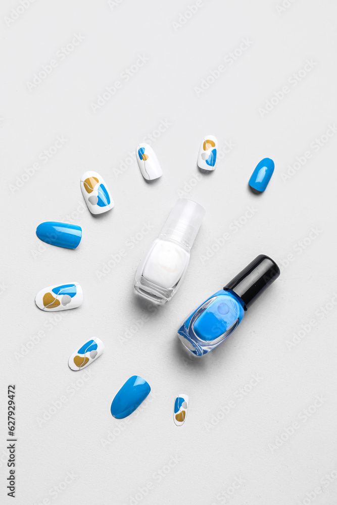 Press-on nails with polishes on white background