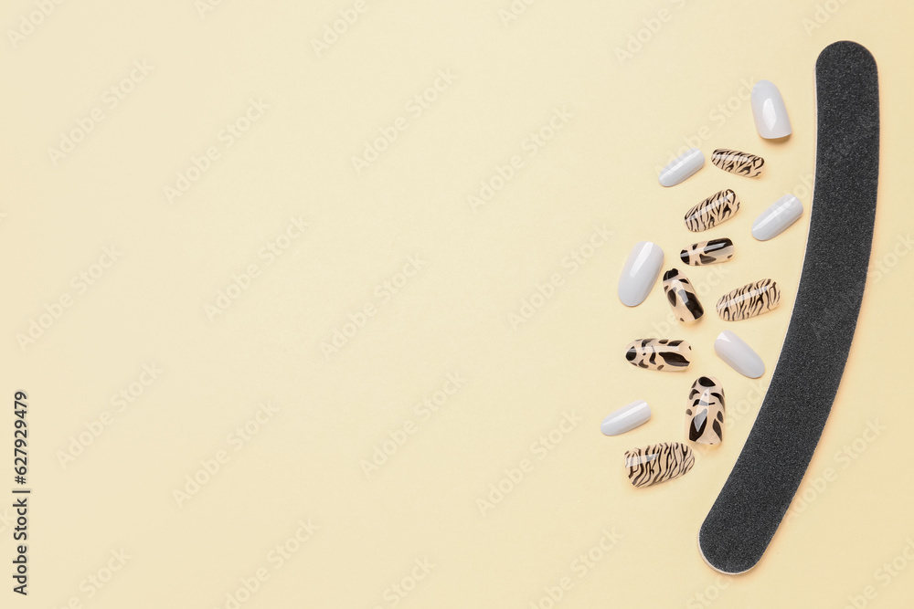 Press-on nails with file on beige background