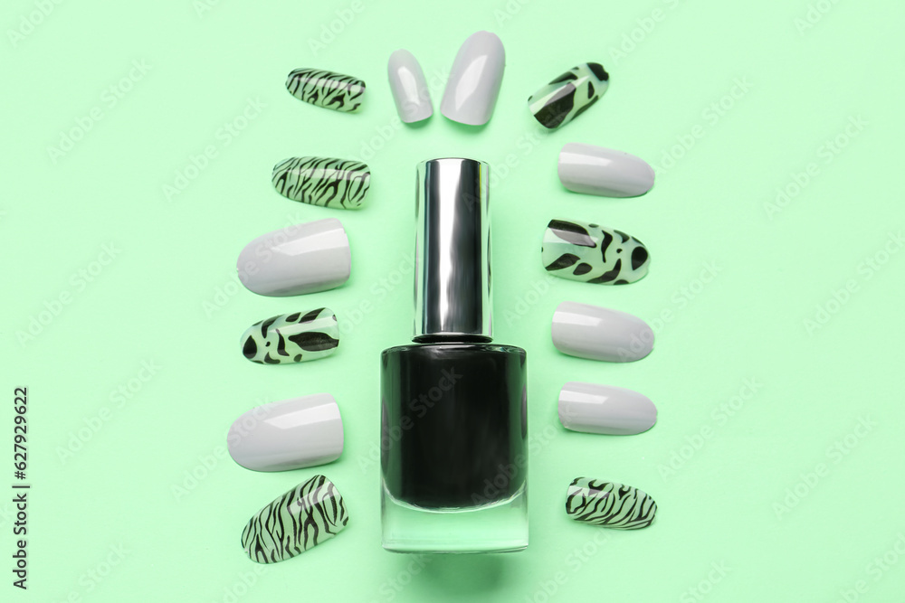 Press-on nails with polish on green background