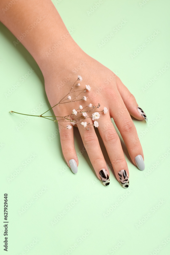 Woman with press-on nails and flowers on green background