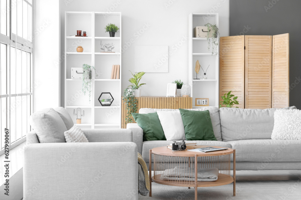 Interior of bright living room with cozy grey sofas and coffee table