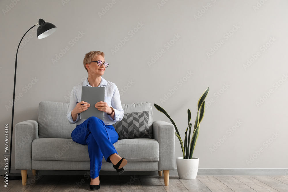 Mature psychologist working with notebook in office