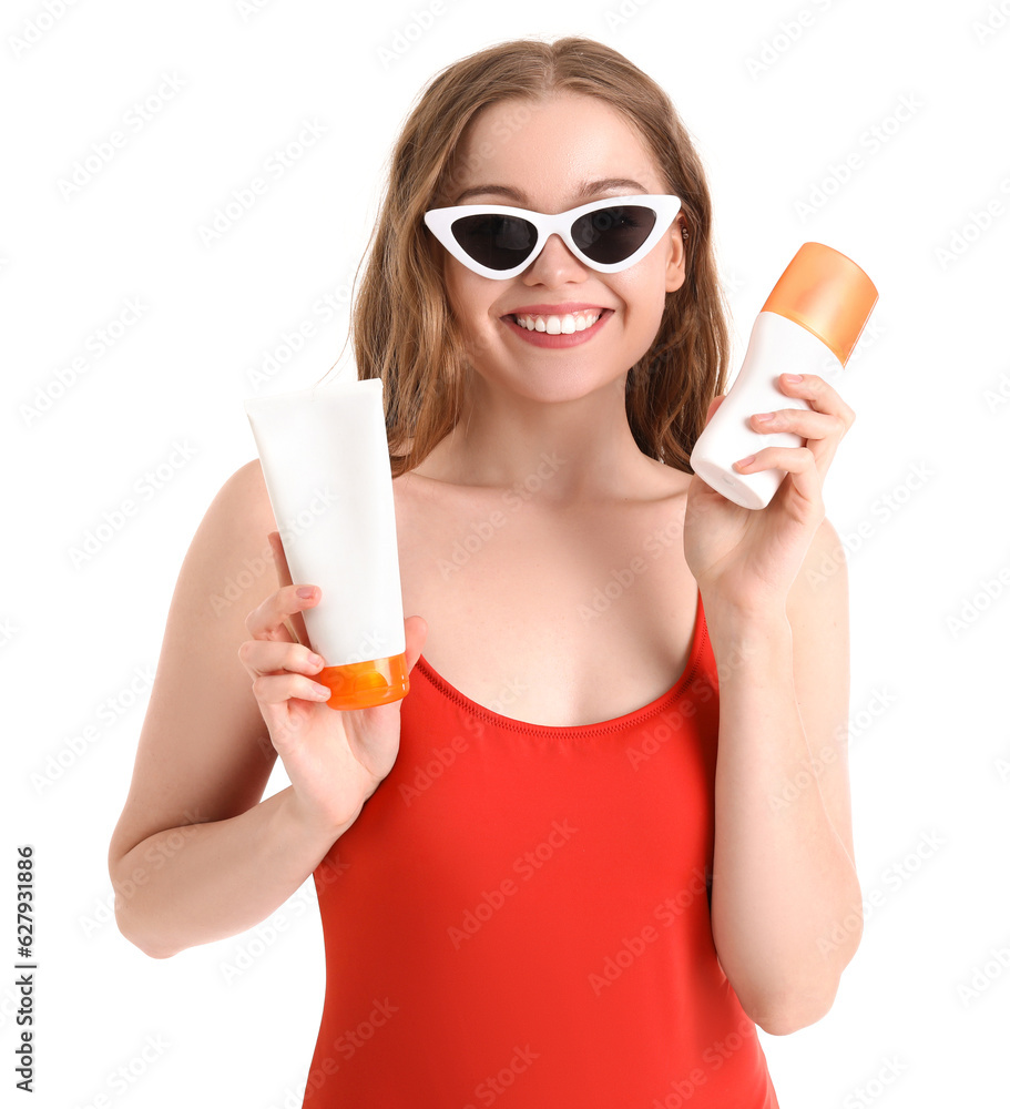 Beautiful young woman with sunscreen creams on white background