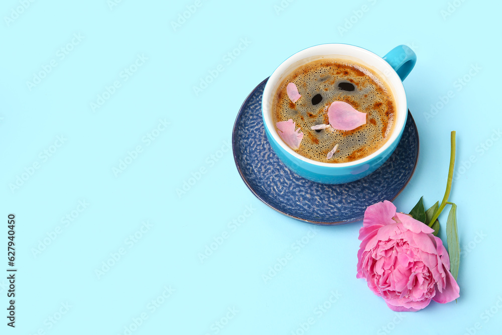 Cup of aromatic coffee and beautiful peony flower on color background