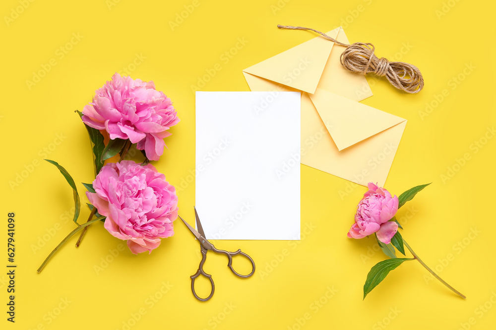 Composition with blank card, scissors and beautiful peony flowers on yellow background