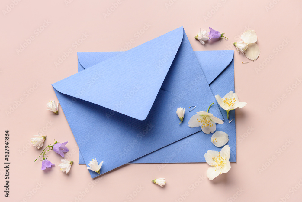 Composition with envelopes and beautiful flowers on color background