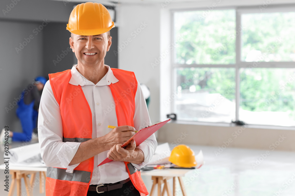 Mature builder with clipboard working in room