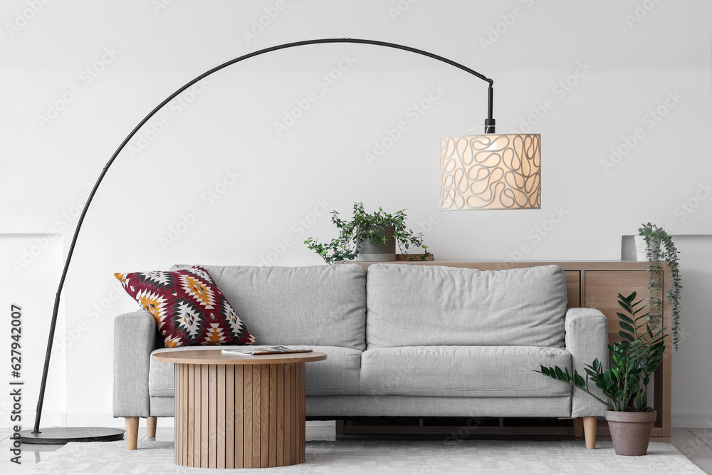 Interior of light living room with lamp, sofa and table