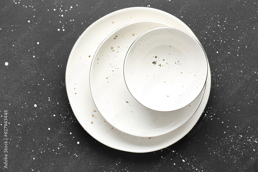 Clean white plates and bowl on black table